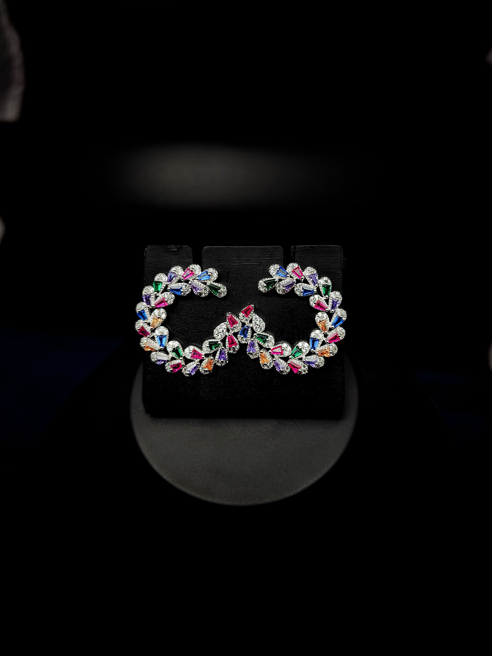 Silver-tone infinity-shaped hoop earrings set with multicolour baguette stones