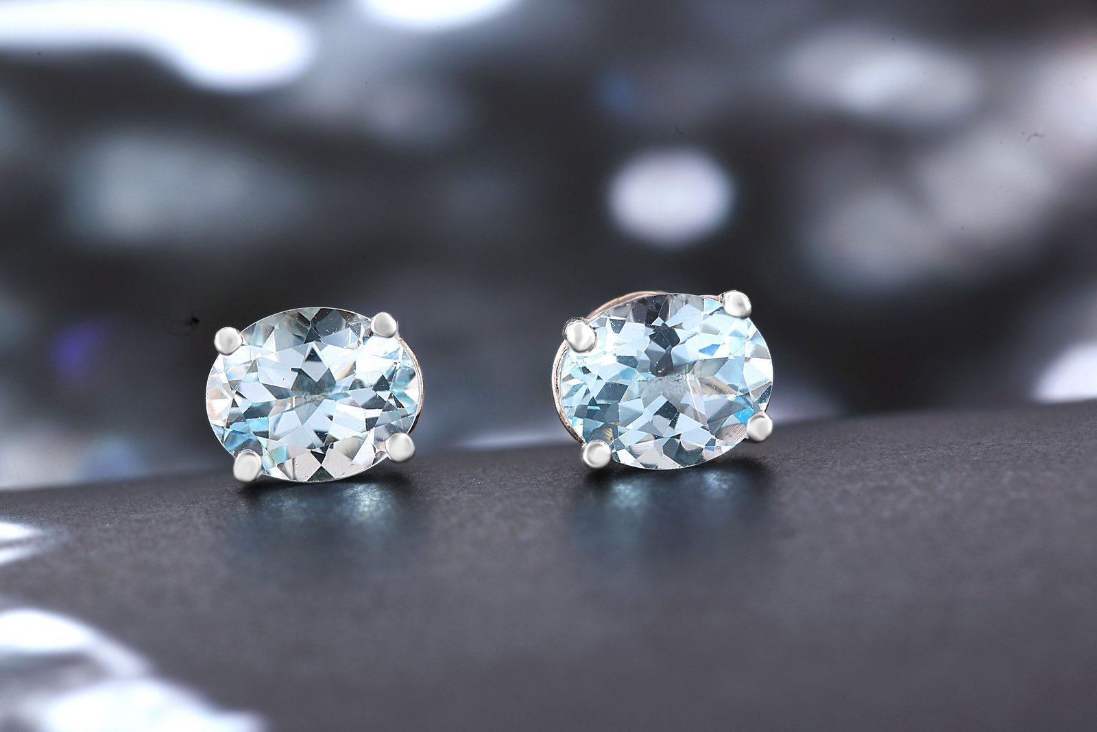 Pair of oval clear stone stud earrings in a silver-tone four-prong setting
