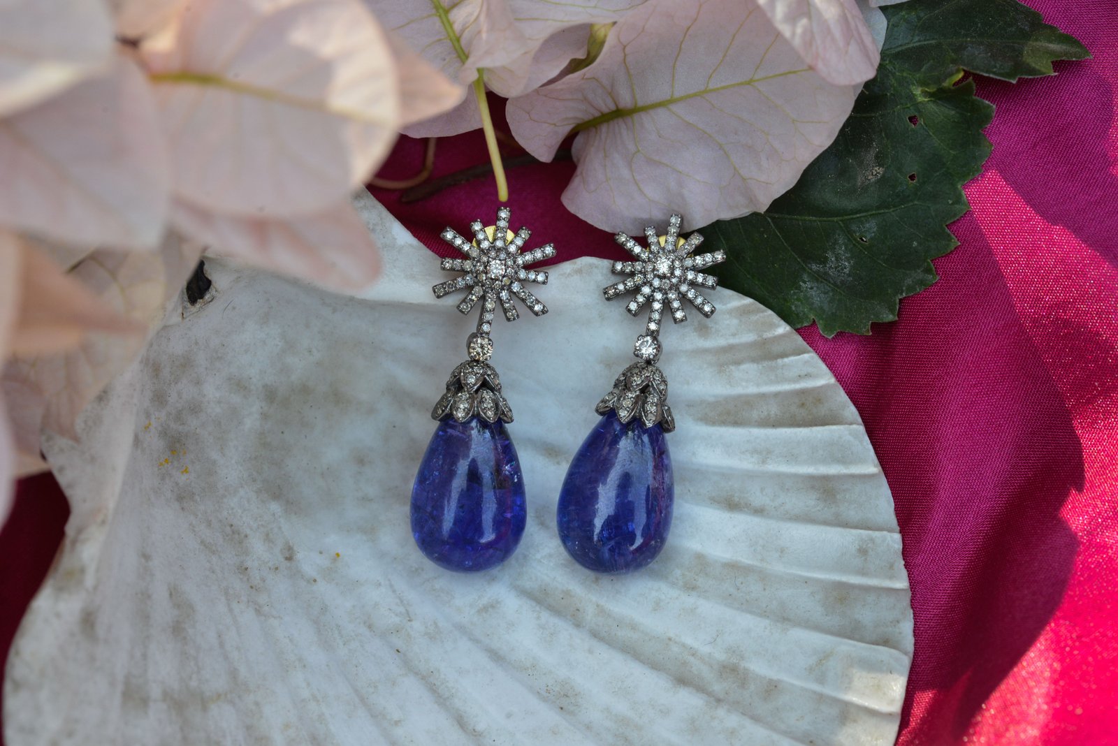 Drop earrings with a starburst stud and a large blue briolette stone, oxidised silver-tone