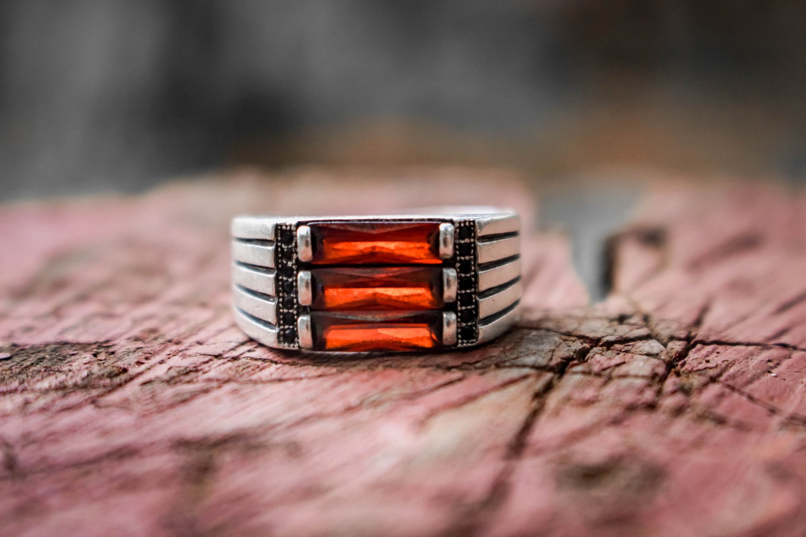 Ring with three vertical red-orange stones in a ridged silver-tone band