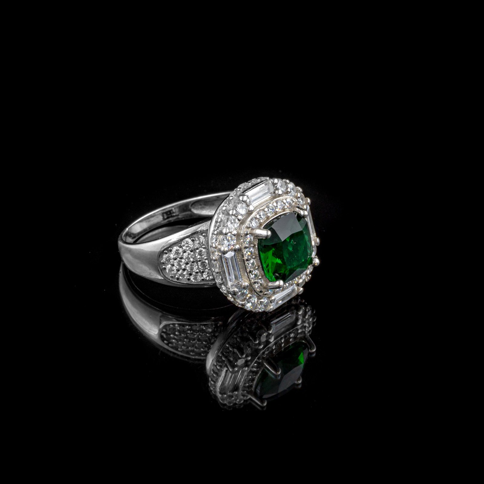 Ring with a cushion-cut green stone framed by a halo of clear stones
