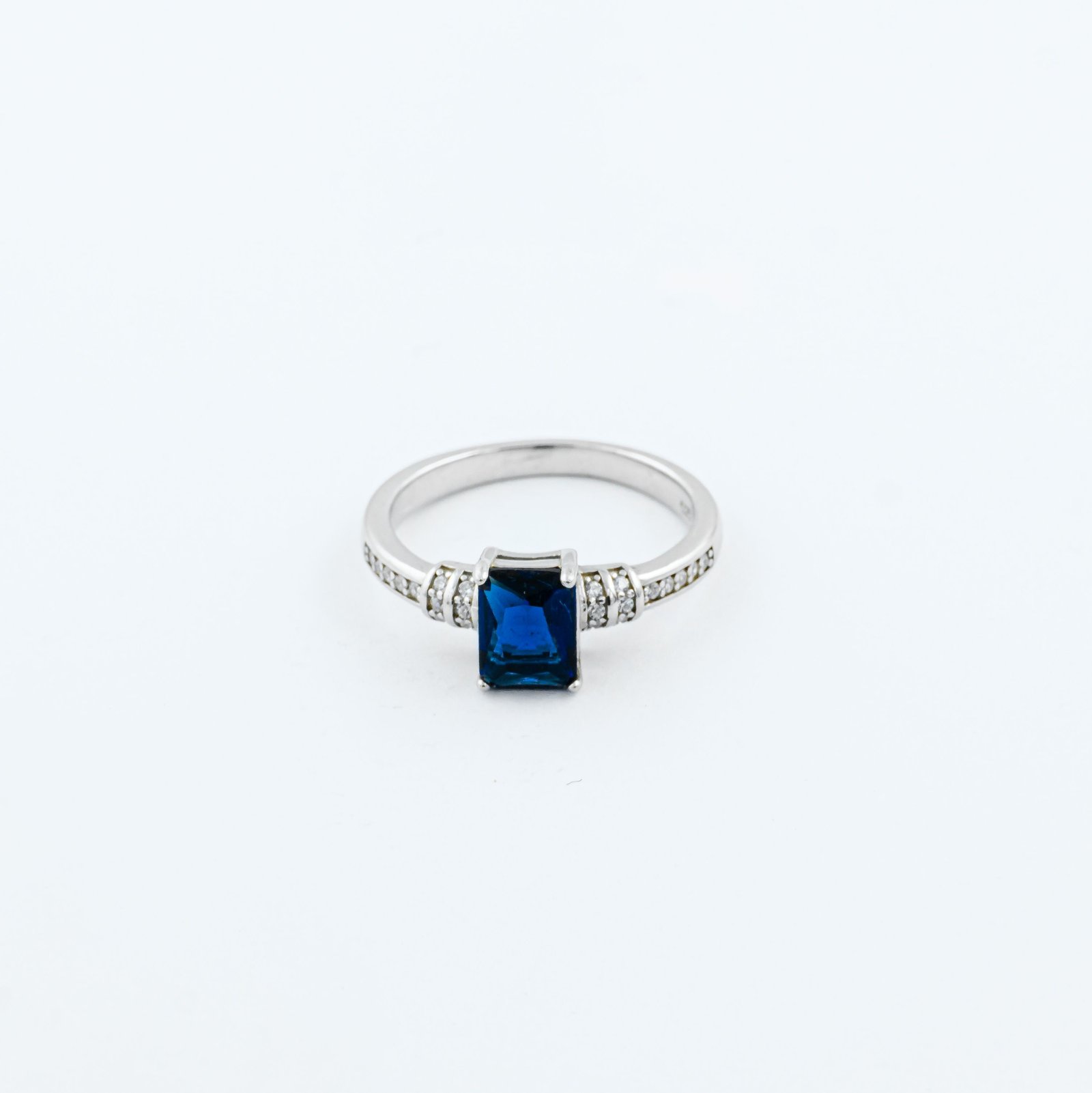 Ring with a rectangular step-cut blue stone on a pavé silver-tone band
