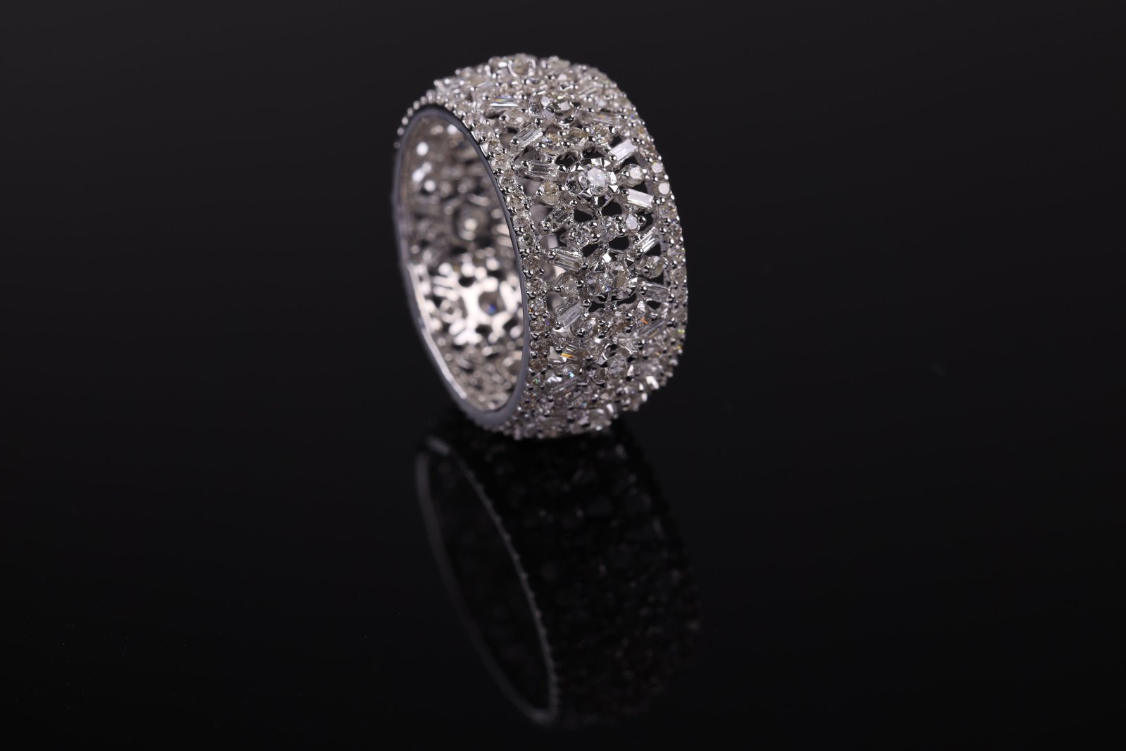 Wide silver-tone band densely set with round and baguette clear stones in a lattice pattern
