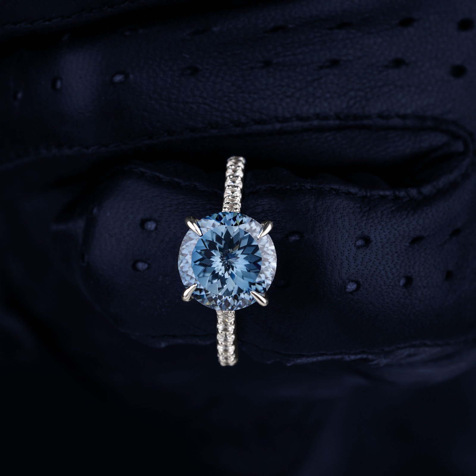Ring with a round pale blue stone in a silver-tone prong setting