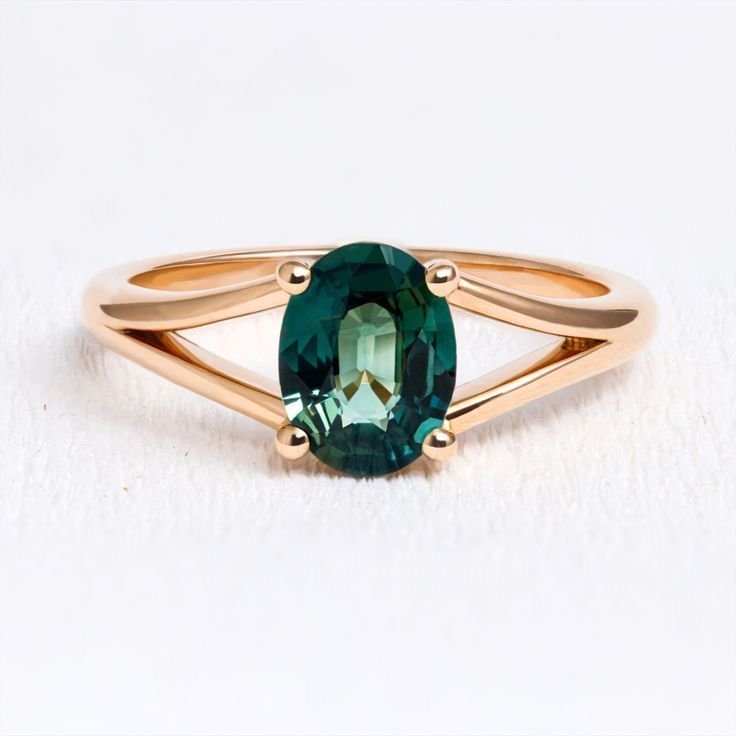 Ring with a green oval stone on a split gold-toned shank